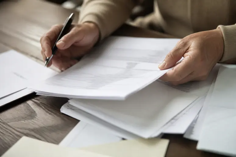 Des documents administratifs sur la perte d'autonomie examinés sur une table en bois.