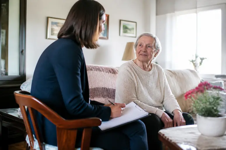 Équipe médico-sociale réalisant une évaluation de l'autonomie lors d'une visite à domicile.