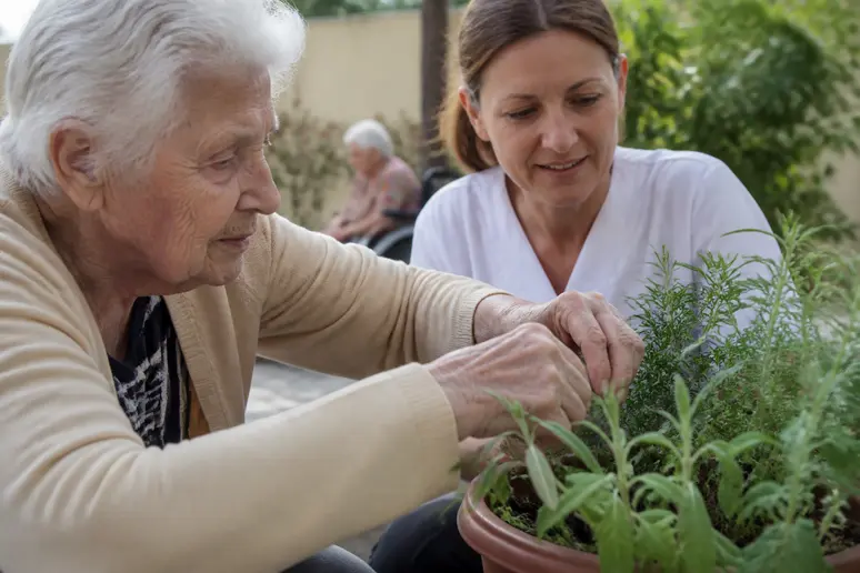 Résident en EHPAD participant à un atelier de jardin thérapeutique pour stimuler ses sens
