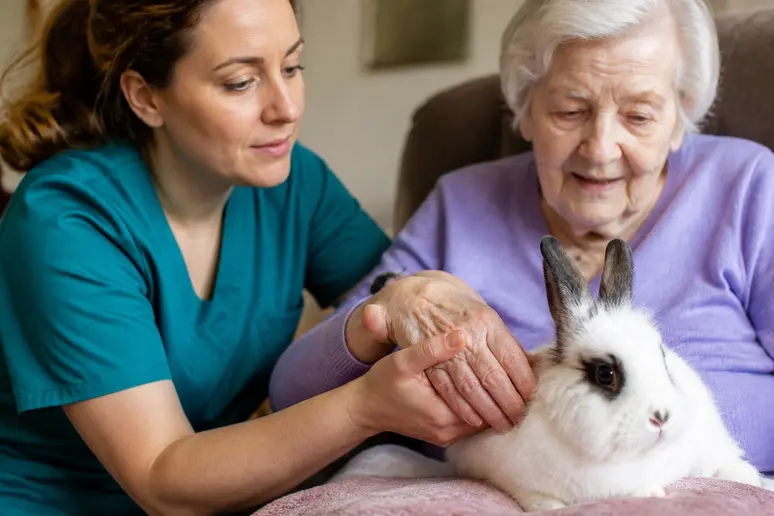 Soignante accompagnant une personne âgée lors d'un atelier de médiation animale en ehpad