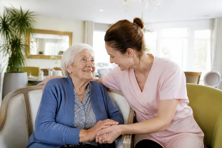 Aide soignante accompagnant une personne âgée en maison de retraite pour illustrer les prestations et suppléments en EHPAD.