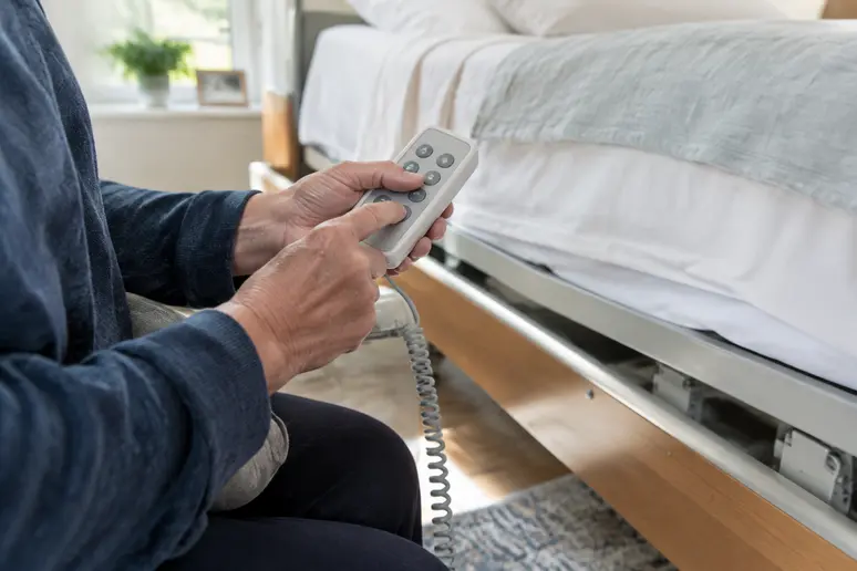 Télécommande électrique d'un lit médicalisé à domicile manipulée pour régler la hauteur du sommier
