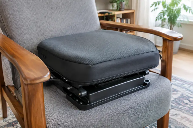 Coussin releveur senior posé sur l'assise d'un fauteuil avec accoudoirs