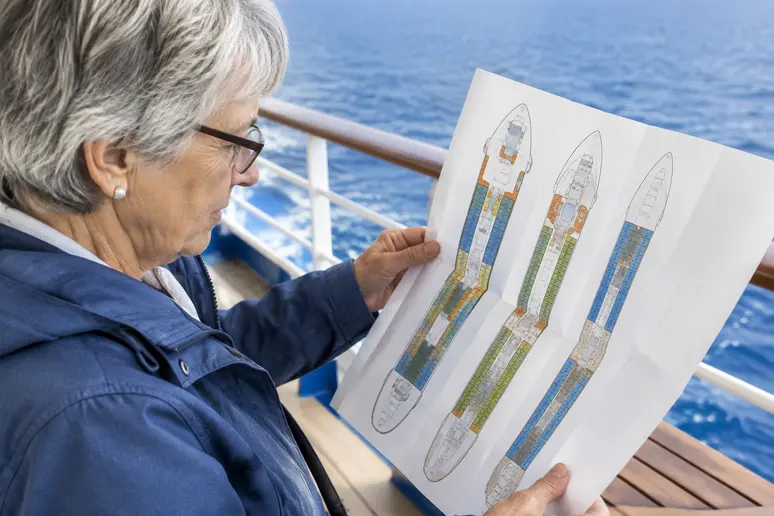 Voyageur senior consultant un plan de pont pour choisir une cabine stable.