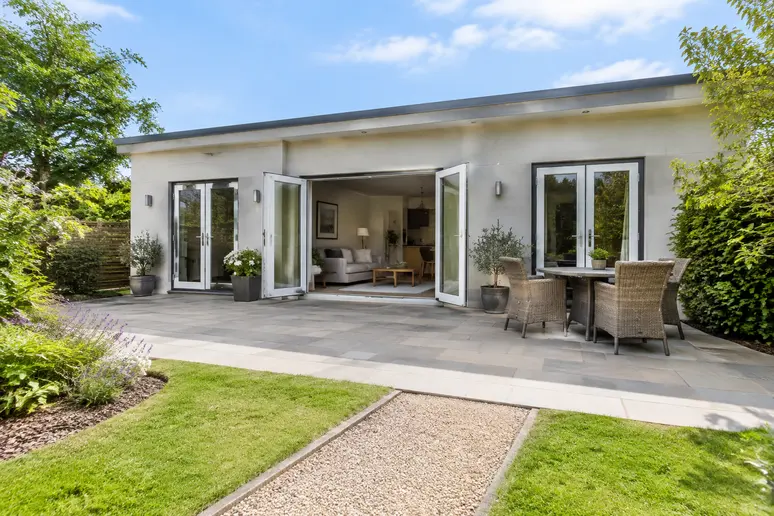 Façade extérieure et accès de plain-pied d'une maison adaptée pour senior avec terrasse
