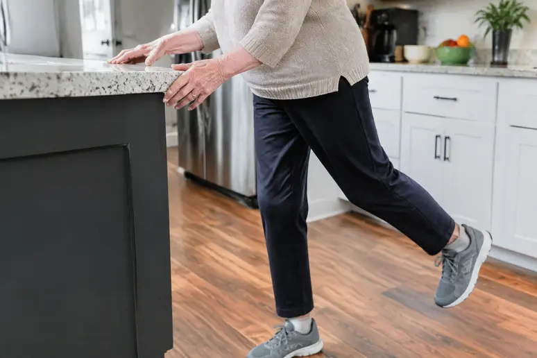 Des mains s'appuient sur un support stable pour pratiquer les exercices de renforcement musculaire senior à domicile