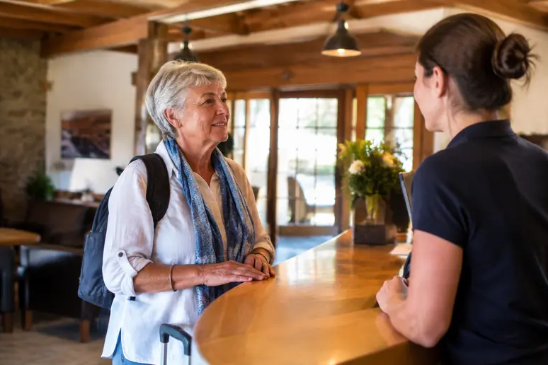 Voyageur senior découvrant sa chambre individuelle dans un village vacances pour un voyage senior solo